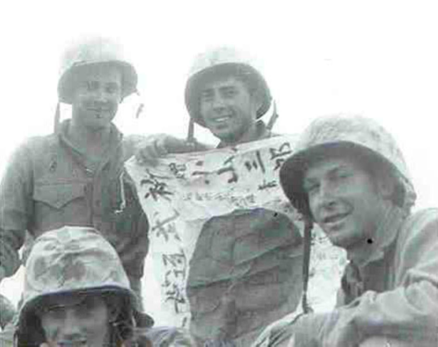 U.S. Marines posing with Japanese good luck flag during battle of Iwo Jima